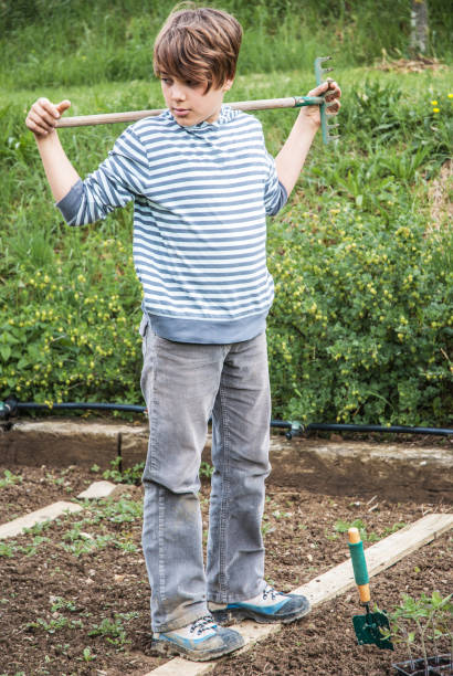 istock Teenage Boy With Rake on His Shoulders 680147768