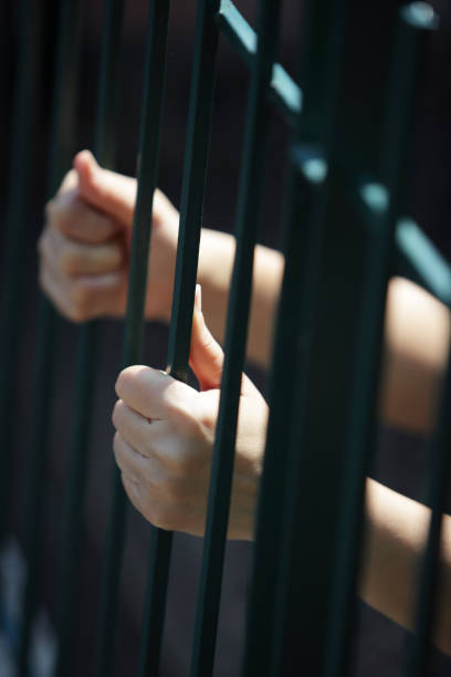 istock hands of prisoner in jail 680148628