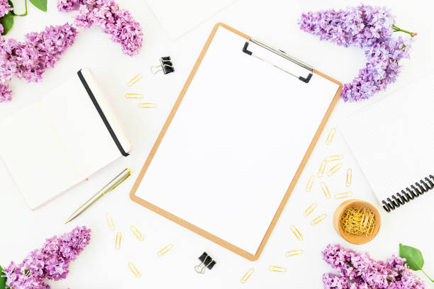 istock Minimalistic workspace with clipboard, notebook, pen, lilac and accessories on white background. Flat lay, top view. Beauty blog concept. 680151628