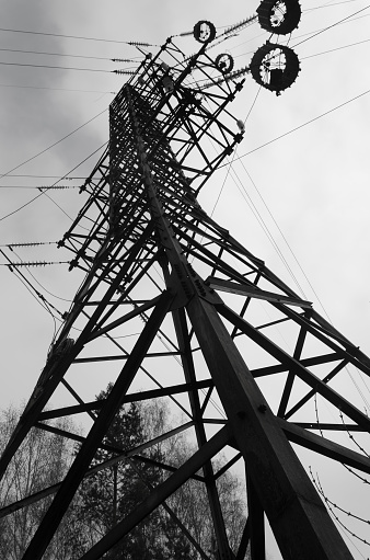 Transmission tower perspective view from below. A high-frequency barrier and wires on a power line. Black and white
