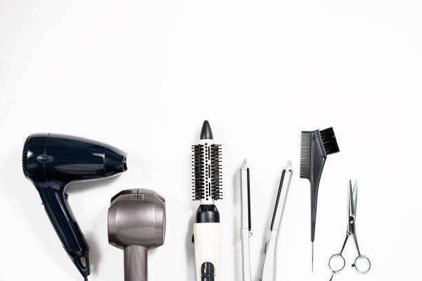 Various hair styling devices on white background, top view Various hair styling tools on white background, top view, copy space curling tongs photos stock pictures, royalty-free photos & images