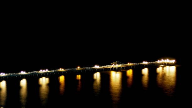 istock The smooth reflection of jetty bridge during the night 680172616