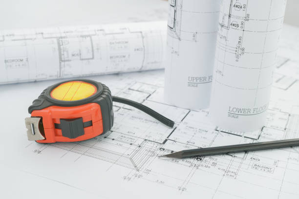 istock architects workplace - architectural blueprints with measuring tape and black pencil on table. 680178554
