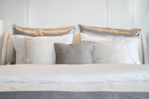 istock Gray color scheme pillows setting on bed with satin finished style bedding 680188118
