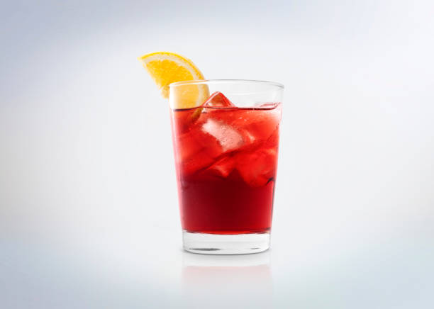 Negroni cocktail drink with ice cubes and orange. A glass with Campari (bitter). Isolated on white background. red drink stock pictures, royalty-free photos & images