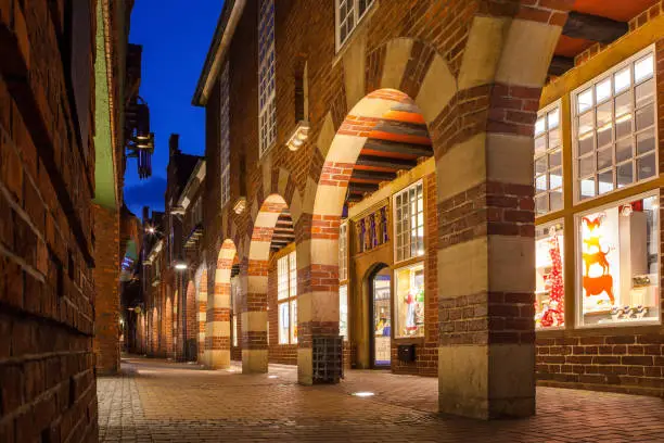 Photo of BREMEN, GERMANY - 16 APR 2016: Boettcherstreet by night in Bremen. Only about 100 m long, it is famous for its unusual architecture and ranks among the citys main cultural landmarks.