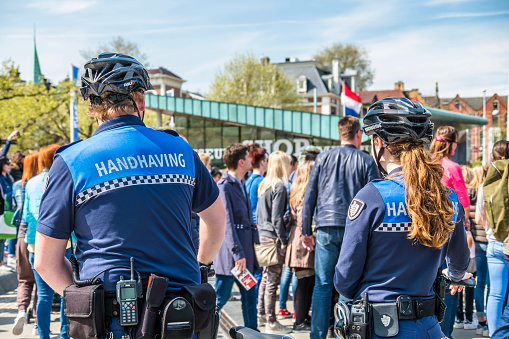 Swedish police in uniforms entering the ice and handball venue, Malmö Arena on a sunny day in Malmö, Sweden