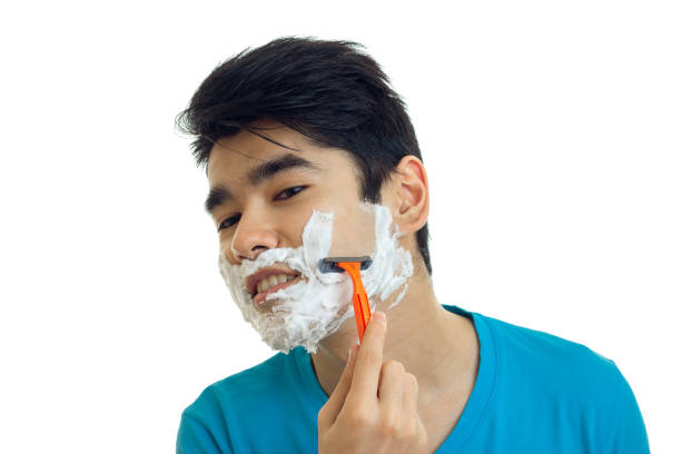 istock black-haired young man with foam on his face shaves machine close-up 680201132