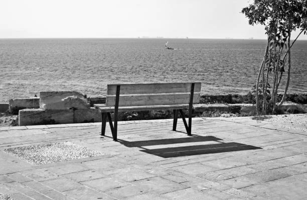 The lonely wooden bench on the seashore.