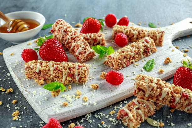 istock Granola bar with strawberries, raspberry honey and white chocolate on cutting board 680214750