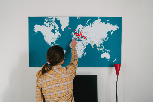 Young Caucasian woman pointing on map near the working place indoors