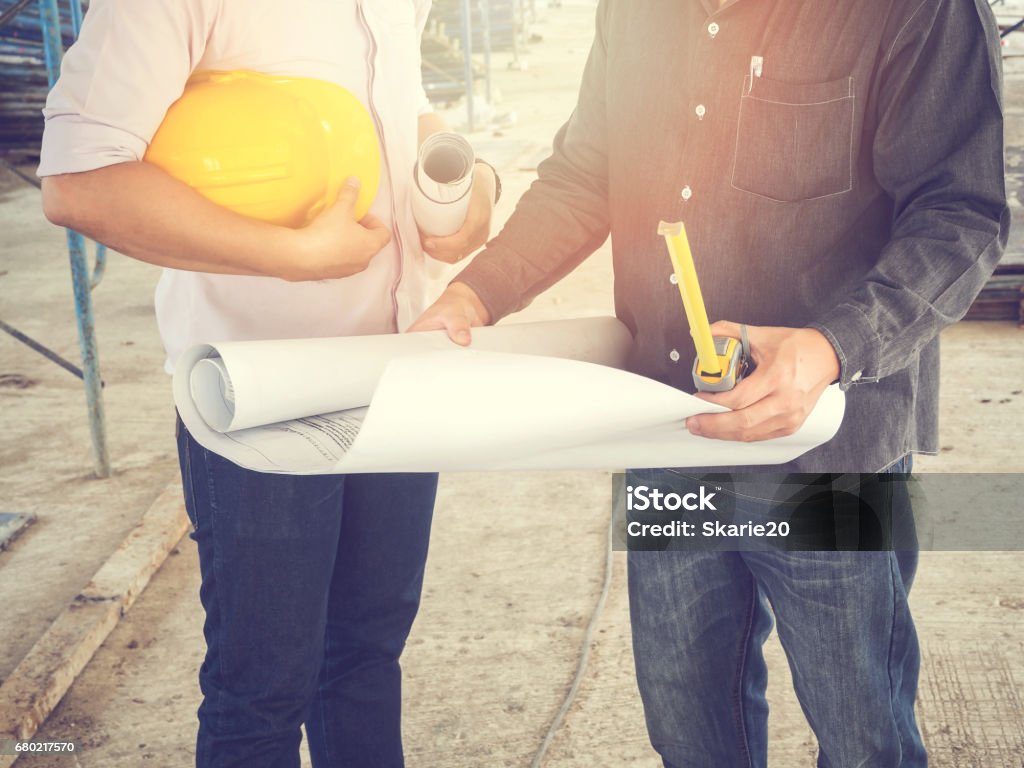 Engineer discussing with foreman about project in building construction site, selective focus Foreperson Stock Photo