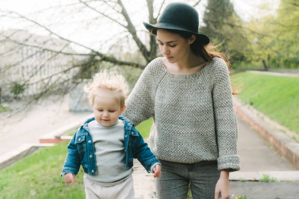 Young Caucasian mother walking with child in the park