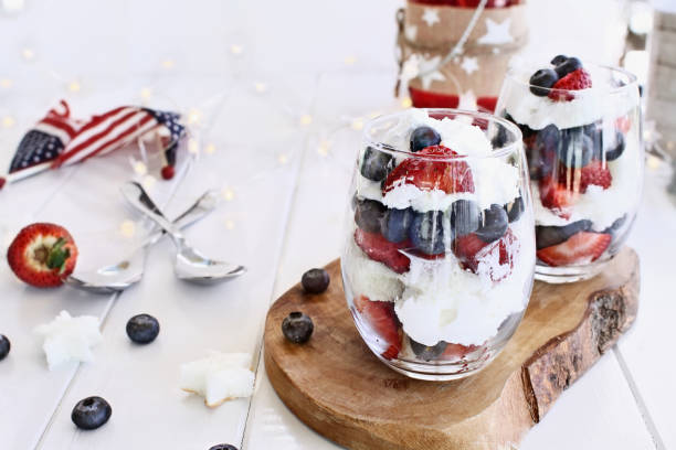 American Blueberry Strawberry Trifles Trifles made with blueberries, strawberries, whipped cream and star shaped pound cake against a white wood background. Perfect for fourth of July. Shallow depth of field with selective focus. trifle stock pictures, royalty-free photos & images