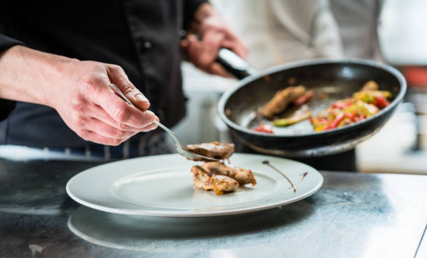 istock Chef finishing food on plate in restaurant kitchen 680249416