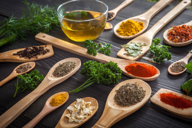 Various spice on wooden spoons with herbs