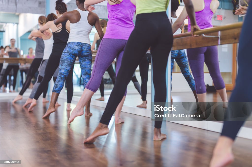 Group of Women Doing Barre  Workout Multiethnic group of young women do barre  workout together at modern gym Barre Stock Photo