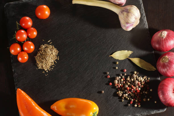 istock Top view of a dark board and vegetables with spices for soup making, copyspace, menu 680251094