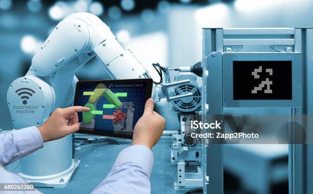 Industry 40 Concept Man Hand Holding Tablet With Performance Check Screen Software And Blue Tone Of Automate Wireless Robot Arm In Smart Factory Background Stock Photo - Download Image Now