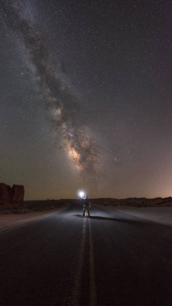 istock Man standing in the road under the Milky Way Galaxy 680264670