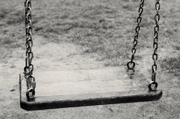 istock Empty swings. The Lost Child. Black and white image. 680274124