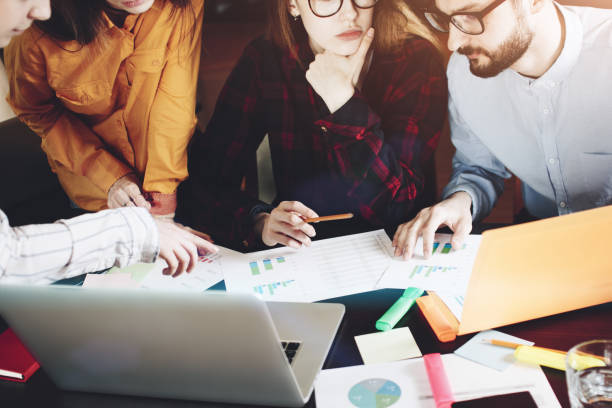 istock Human hands with paper, gadget and notebook during discussion in modern loft office 680286536