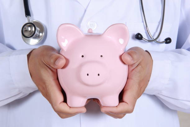 istock Doctor hand holding piggy bank 680287462