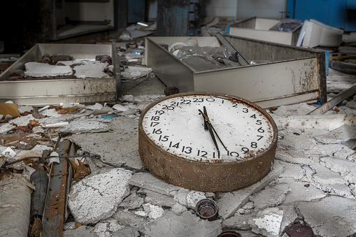 24 hour broken clock on floor of abandoned laboratory