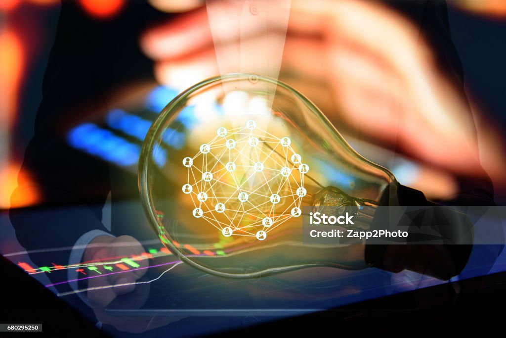 Fintech Investment Financial Internet Technology Concept. Light bulb on tablet and Stock graph and business technology icon with abstract electronic circuit background Financial Technology Stock Photo