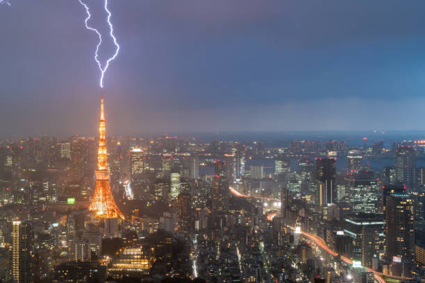 tempesta di fulmini sulla città di tokyo, giappone nella notte con un fulmine sulla torre di tokyo. temporale a tokyo, giappone. - office tool flash foto e immagini stock