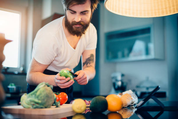 istock Handsome bearded man preparing food in the modern kitchen 680304444