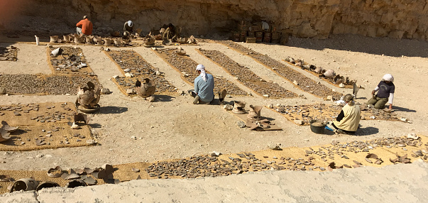 Archaeologists working to identify, sort, catalog and assemble ancient Egyptian pottery pieces in the Valley of the Kings in the desert near Luxor Egypt.
