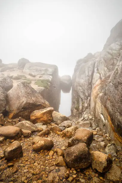 Photo of Famous Kjerag stone, hanging on the cliff between two high rocks on the Lysefjord coast. Norway. Popular travel destination in Norway, Europe.