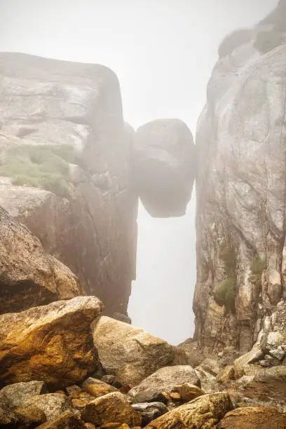 Photo of Famous Kjerag stone, hanging on the cliff between two high rocks on the Lysefjord coast. Norway. Popular travel destination in Norway, Europe.