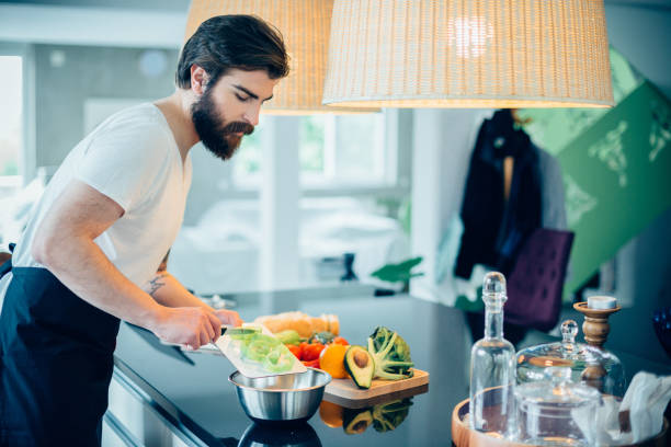 istock Handsome bearded man cutting vegetables to prepare healthy meal 680323596