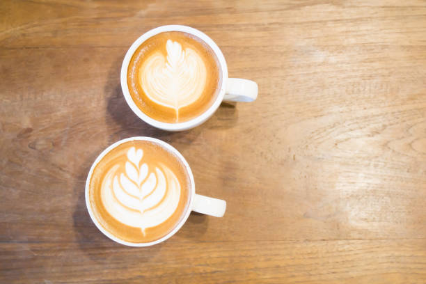 istock Cup of latte art coffee on wooden table 680334134