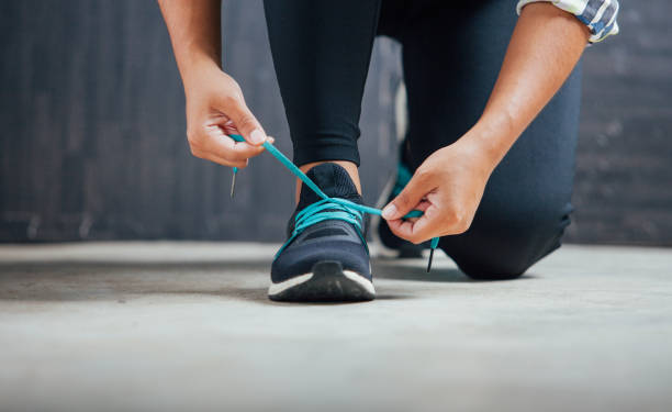 istock Female runner tying her shoes preparing for a run 680346294