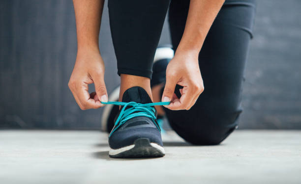 corredor abuna atesus sus zapatos preparándose para una carrera - zapatillas de deporte fotografías e imágenes de stock