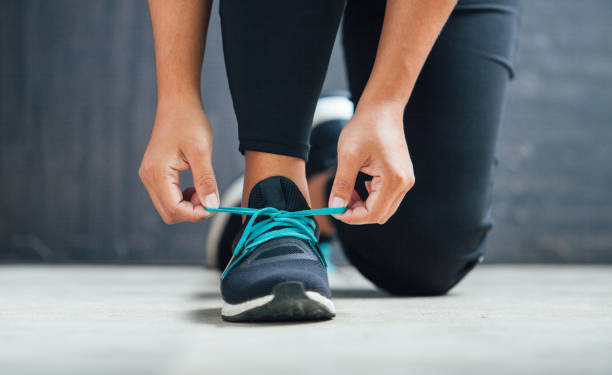 달리기를 준비하는 그녀의 신발을 묶는 여성 주자 - 스포츠 신발 뉴스 사진 이미지