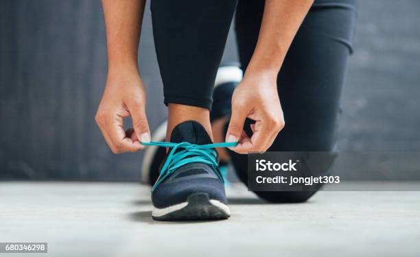 Female Runner Tying Her Shoes Preparing For A Run Stock Photo - Download Image Now - Tying, Sports Shoe, Shoe