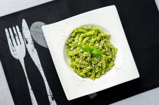 Pesto pasta from above. Rotini pasta with basil pesto sauce, grated parmesan cheese and fresh pepper. This Italian dish makes a delicious meal by itself or can be used as a pasta salad side.