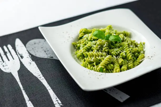 Fresh pesto pasta dish. Rotini pasta with basil pesto sauce, grated parmesan cheese and fresh pepper. This Italian dish makes a delicious meal by itself or can be used as a pasta salad side.