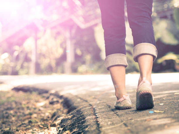 istock woman walking towards on the road side. 680360040