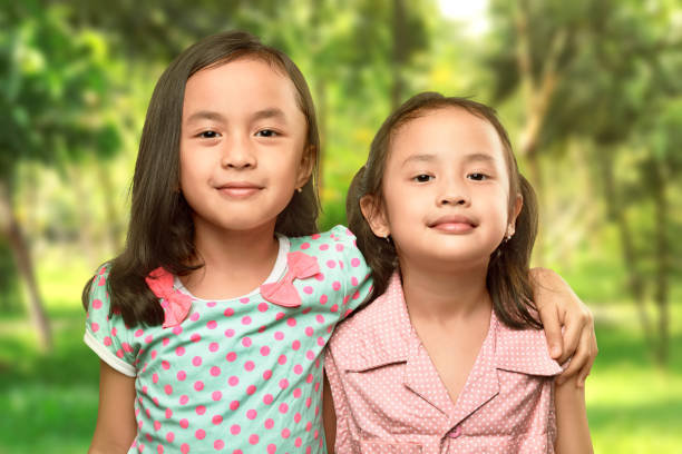 istock Funny two little sisters standing and hugging 680363036