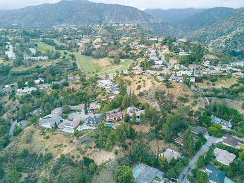 An aerial shot of a neighborhood next to the mountains.