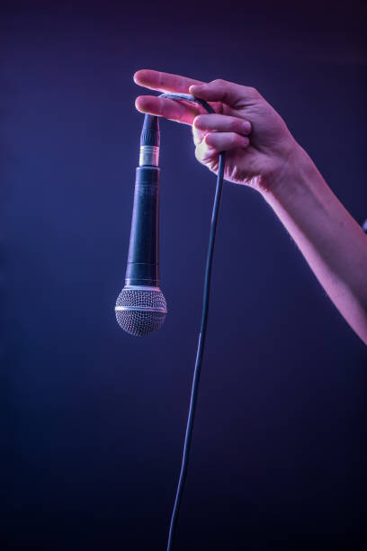 istock hand with microphone on a black background, the music concept, beautiful lighting on the stage 680368310