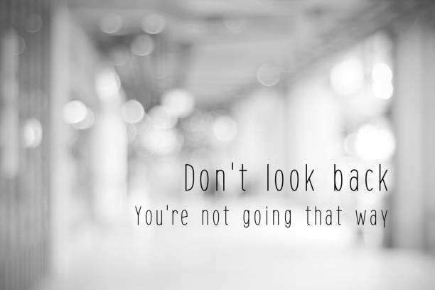 Don't look back, you're not going that way, life quotation on blur abstract black and white bokeh light background