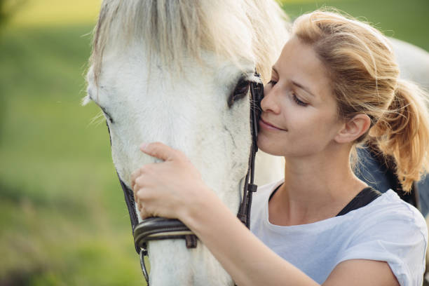 istock Blonde woman with white horse 680373648