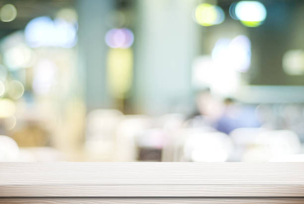 istock Empty white wood table and blurred cafe with bokeh light background, product display montage 680373842