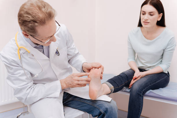 istock Intent local expert examining ladies foot 680377428